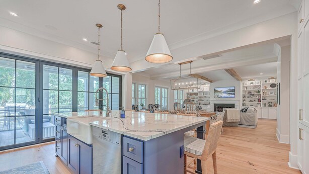 A spacious kitchen with a large island, pendant lighting, and a view of the outdoors through large windows. - 2410 The Bent Twig (Seabrook Island)