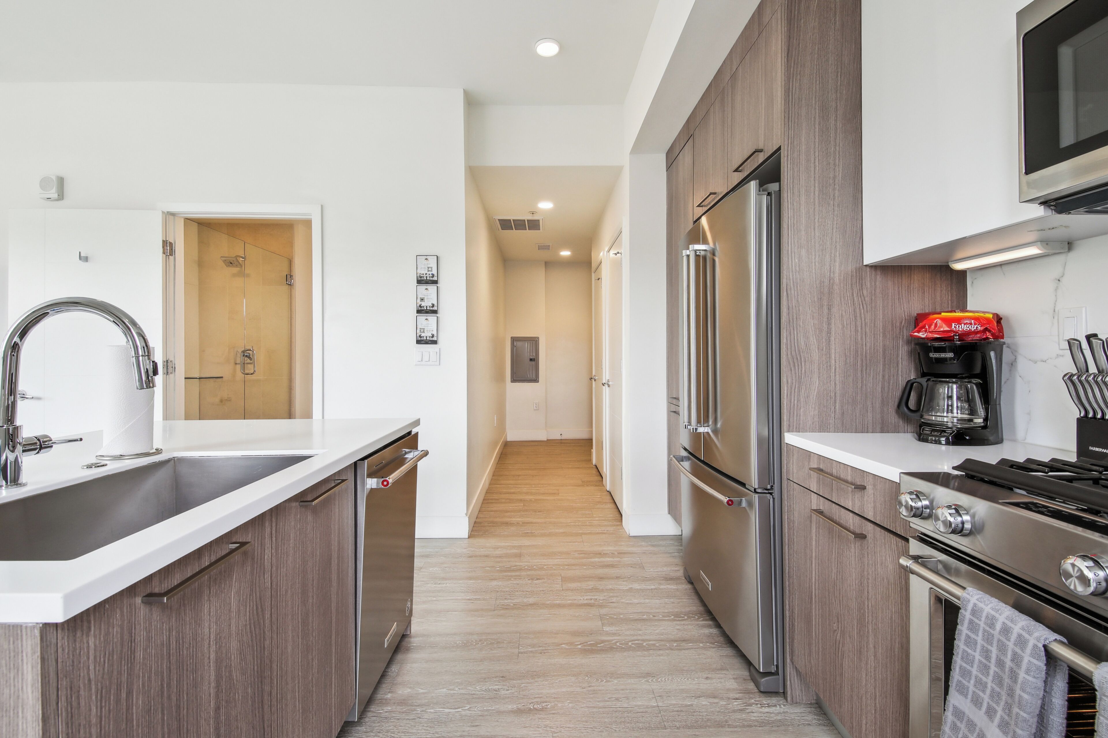 A modern kitchen with stainless steel appliances, a built-in oven, and a coffee maker.