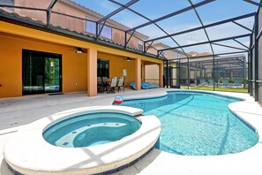 A swimming pool with a hot tub, covered patio seating, and a glass-enclosed area. - 2616 Tranquility, Kissimmee, 6 BED (Kissimmee)