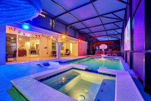 Une piscine intérieure dotée d’un espace abrité, de sièges et d’un panier de basketball.