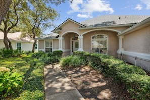 A residential house with a well-maintained front yard, a pathway leading to the entrance, and a clear sky. - 2888 Tidewater Drive (Fernandina Beach)