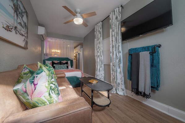 Un salon confortable avec un canapé, une petite table et un ventilateur de plafond.