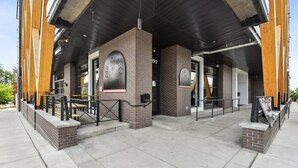 A building with a brick facade, large windows, and outdoor seating area with tables and chairs. - 2880: Above the Cityline Elegance at Espadin (Denver)