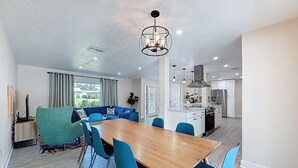 Una cocina moderna con armarios blancos, un refrigerador de acero inoxidable y un horno empotrado.