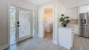 Una cocina moderna con electrodomésticos de acero inoxidable, horno empotrado y una encimera con una planta en maceta.
