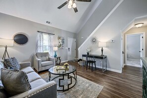A spacious living room with a sofa, armchair, coffee table, and a dining area with a table and chairs. - 29 Middleton Court, Cartersville (Cartersville)