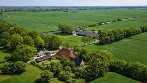 Vista aérea de una propiedad rural con un extenso campo, un pequeño edificio y un camino.