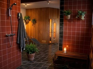 Ein Badezimmer mit Dusche, einer Sitzbank und Topfpflanzen.
