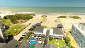 Un hôtel situé en bord de mer, doté d’une piscine, d’un accès direct à la plage et de plusieurs bâtiments.