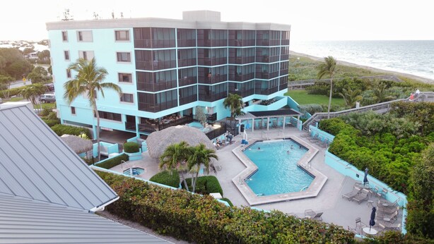 Ein Hotel mit Poolbereich, inklusive einem kleineren Pool und Liegestühlen.