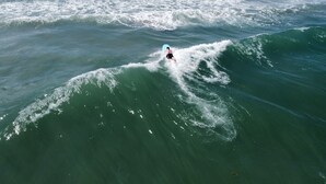 Eine Person reitet auf einer riesigen Welle im Meer.