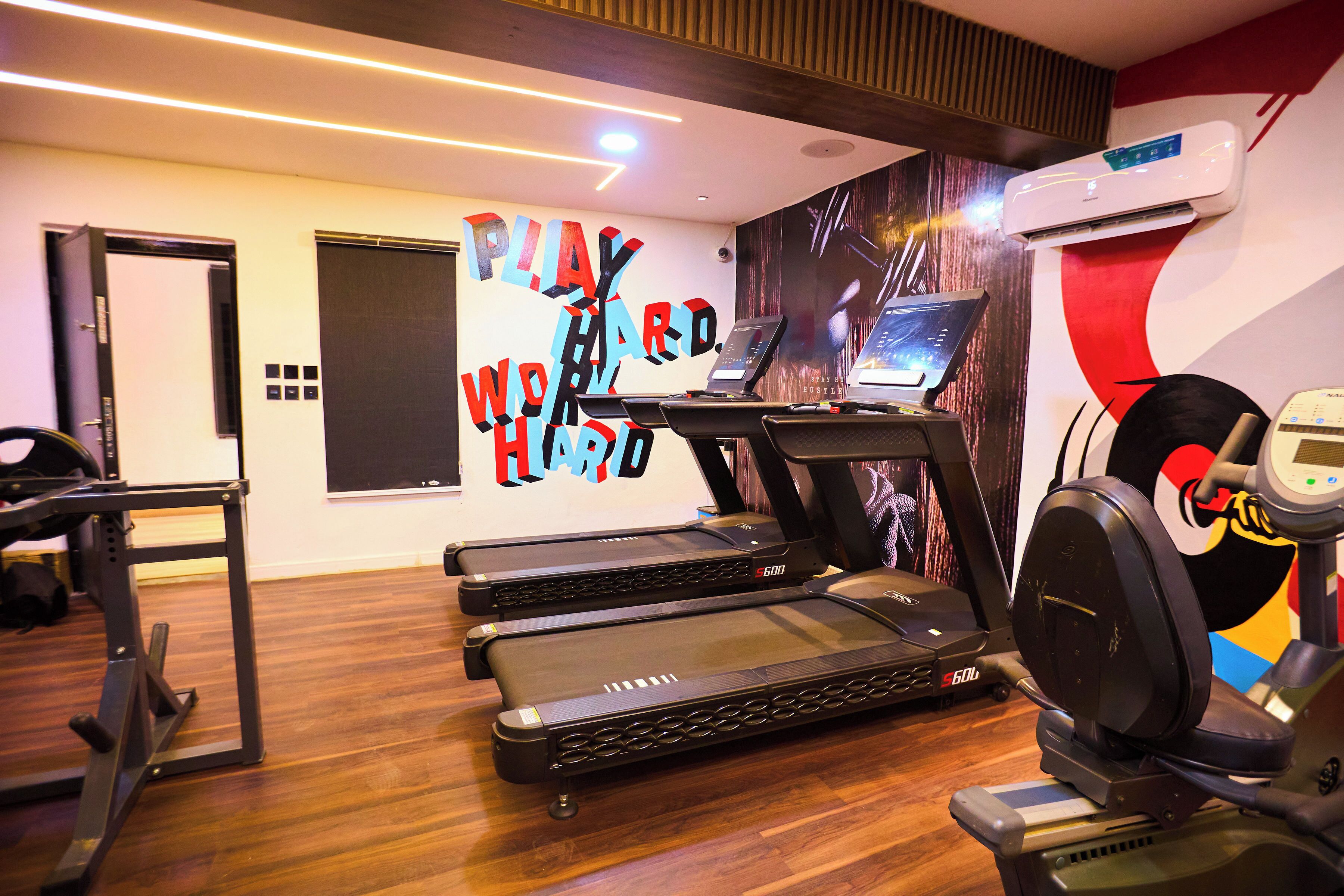 Une salle de sport équipée de tapis de course, d’un vélo d’appartement et d’un appareil d’aviron.