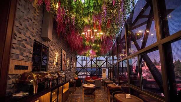 Ein Restaurant mit modernem Ambiente, das eine lange Theke mit Buffet, Holztische und Stühle bietet.