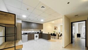 Uma cozinha moderna com uma ilha central, eletrodomésticos embutidos e uma área de refeições com mesa e cadeiras.