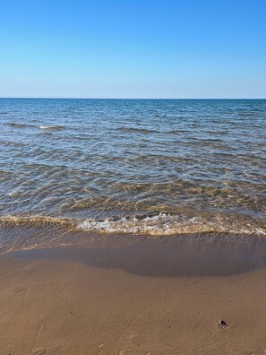 A beach with clear water and a sandy shore. - Waterfront Warbler Way Cottage on Bass Lake + Tawas Beaches, Parks, OHV & Hiking (National City)