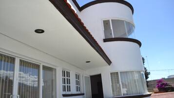 Um edifício branco com fachada curva, janelas grandes e uma porta.