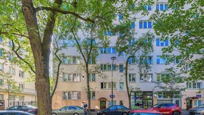 A multi-story residential building with a visible entrance and a door marked with the number 21. - Apartment with Balcony in the Center | Air Conditioning and View (Warszawa)