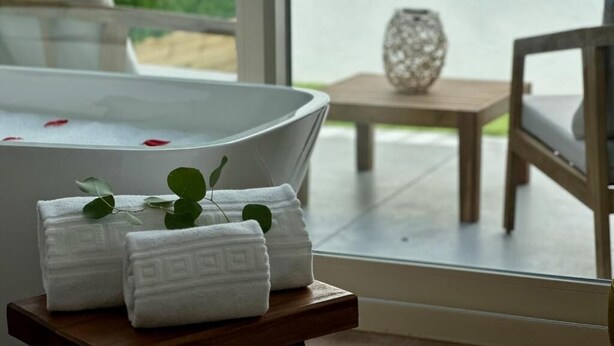 Un área de spa con hidromasaje, toallas y un jarrón decorativo.