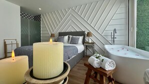 Un dormitorio moderno con cama, mesita de noche y una bañera grande.