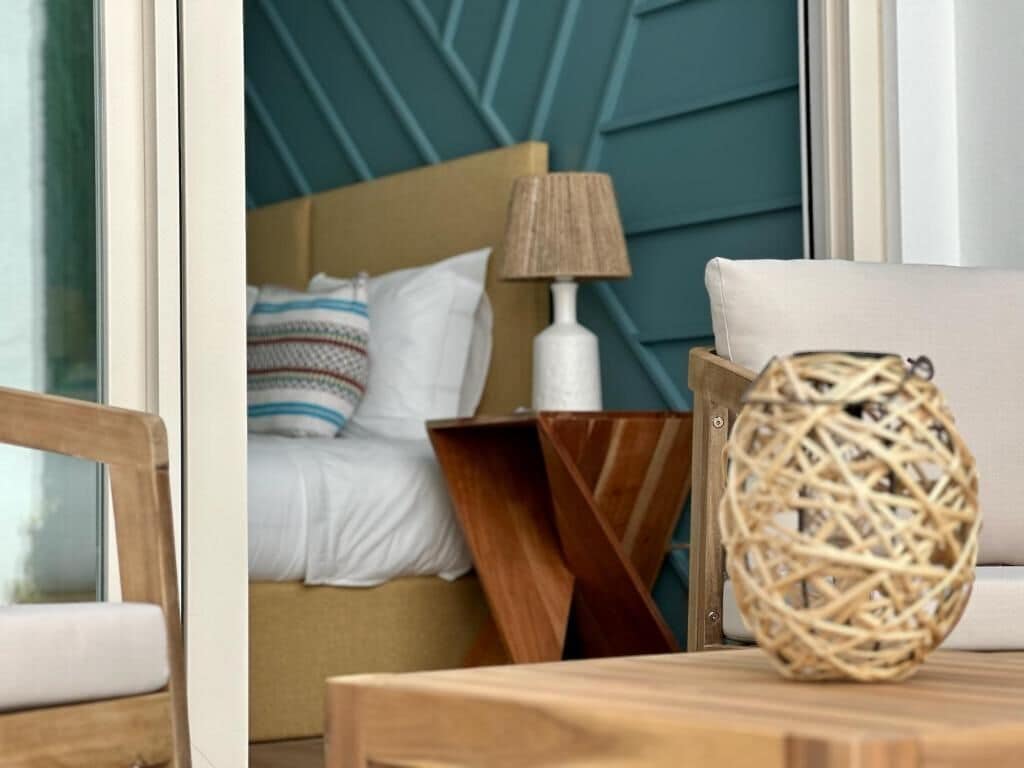 Une chambre à coucher avec un lit, une table de chevet, une lampe et un panier en osier.