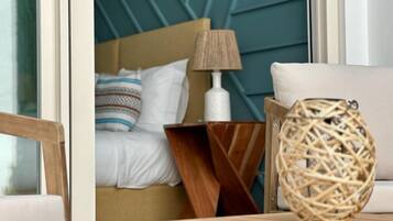 Une chambre à coucher avec un lit, une table de chevet, une lampe et un panier en osier.