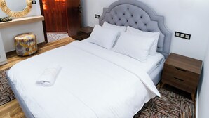 A neatly arranged bedroom with a large bed, a wooden nightstand, a bedside table, a hanging light fixture, and a mirror on the wall. - Cozy 1-Bedroom Studio with AC in beautiful Chefchaouen (Chefchaouen)
