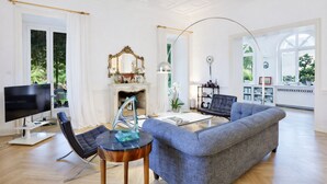 A spacious living room with a fireplace, a television, and a comfortable seating area. - Casa Lalen,
Luxury Apartment with Jacuzzi and Terrace in the Heart of Sorrento. (Sorrento)