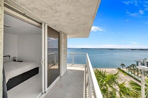 A balcony with a bed, a view of the sea, and a pool area. - 2-bedroom apartment in fantastic Miami with ocean view (Miami)