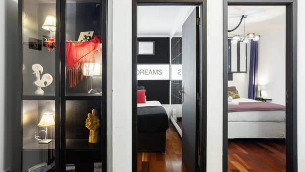 Une chambre d’hôtel avec un lit, une table de chevet, une lampe et un objet décoratif sur le mur.