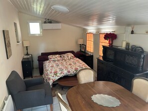 Una habitació amb un llit, una escriptori, una cadira, una taula i una finestra.