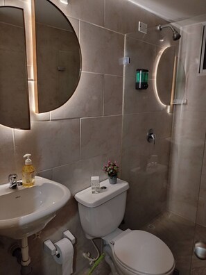 A bathroom with a sink, toilet, and shower. - Apartment in the heart of the city with views 301 (Medellín)