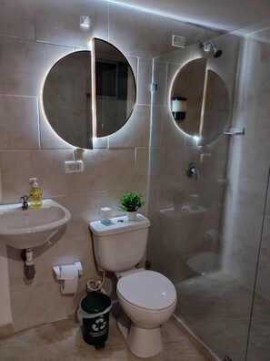 A modern bathroom with a sink, toilet, and shower. - Apartment in the heart of the city with views 301 (Medellín)