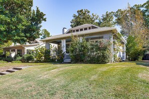 A two-story house with a covered porch, a chimney, and a well-maintained lawn. - 1 Mi to Overton Park: Extended Stay in Memphis! (Memphis)