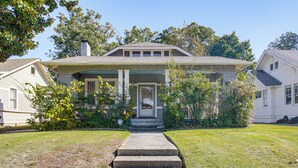 A two-story house with a front porch, a chimney, and a well-maintained lawn. - 1 Mi to Overton Park: Extended Stay in Memphis! (Memphis)