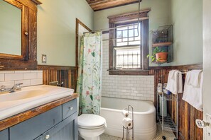 A bathroom with a wooden vanity, white sink, toilet, and a bathtub. - 1 Mi to Overton Park: Extended Stay in Memphis! (Memphis)