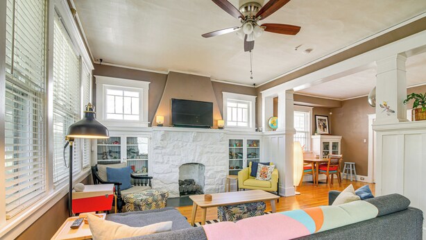 A spacious living room with a fireplace, a ceiling fan, and a dining area with a table and chairs. - 1 Mi to Overton Park: Extended Stay in Memphis! (Memphis)