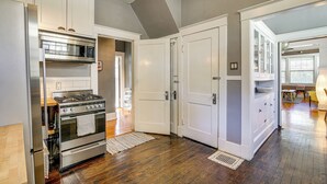 A kitchen with white cabinets, stainless steel appliances, and hardwood flooring. - 1 Mi to Overton Park: Extended Stay in Memphis! (Memphis)