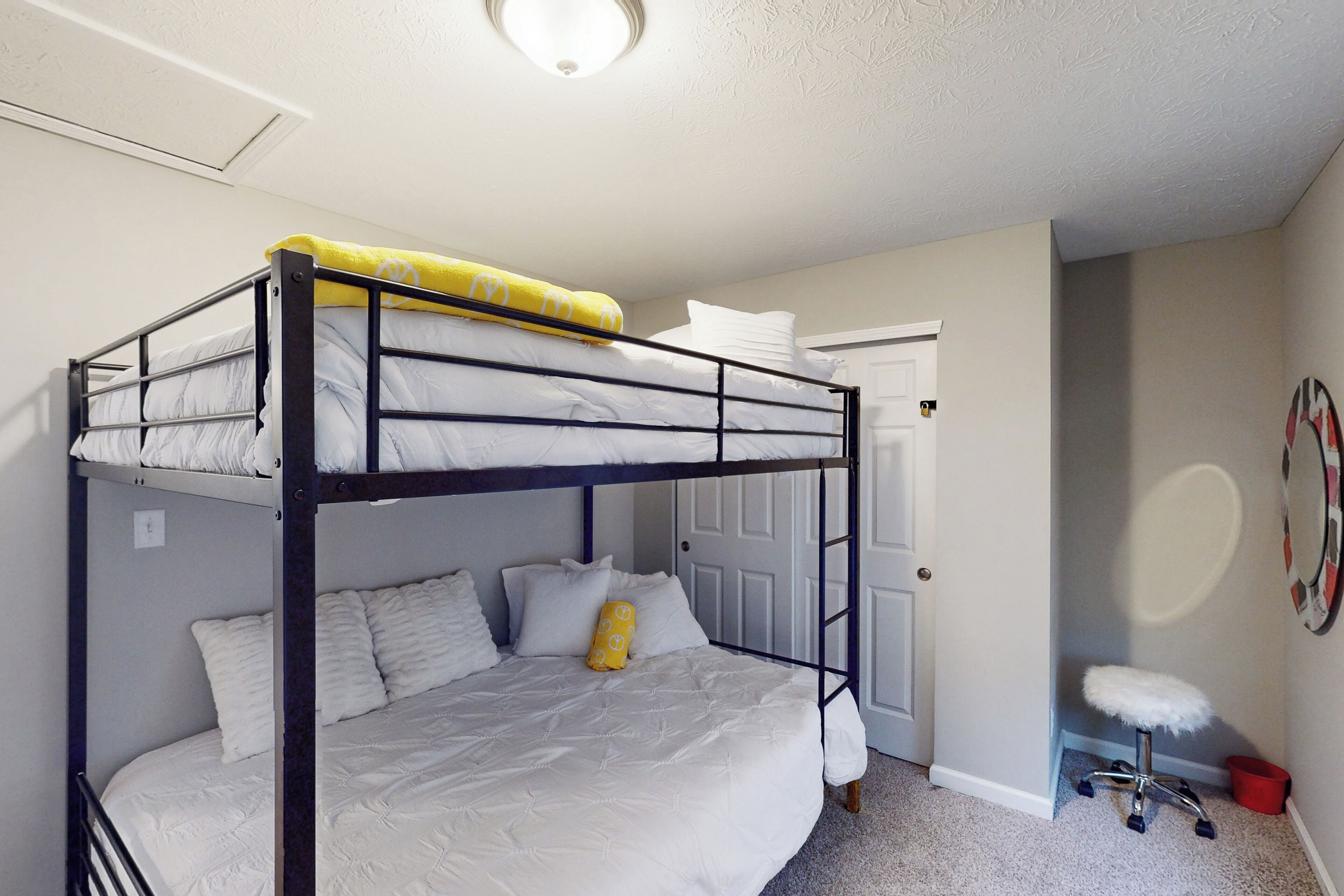 Un lit superposé avec une couverture jaune et un oreiller blanc.