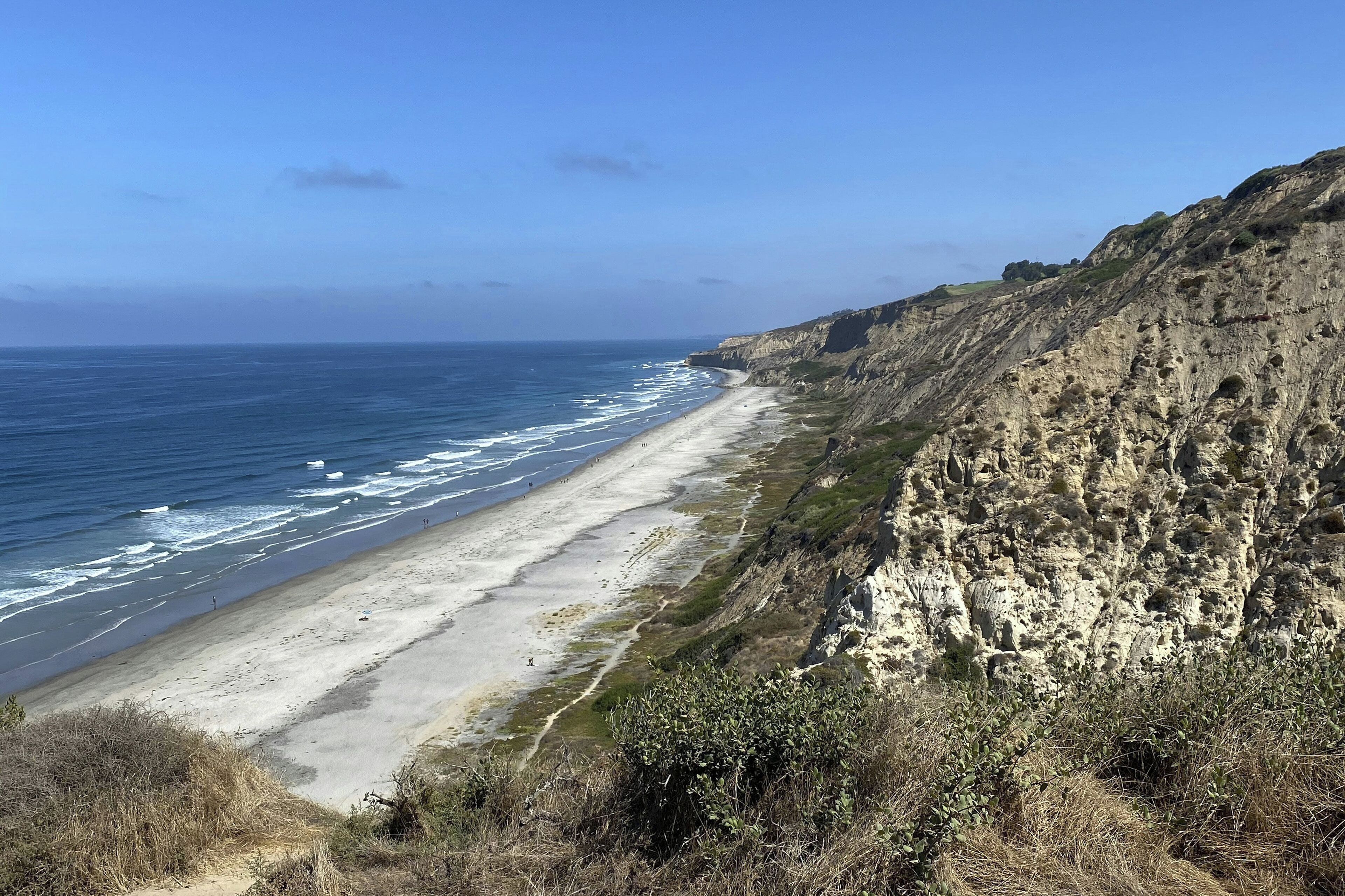 Eine Küstenlandschaft mit Strand, Klippen und Ozean.