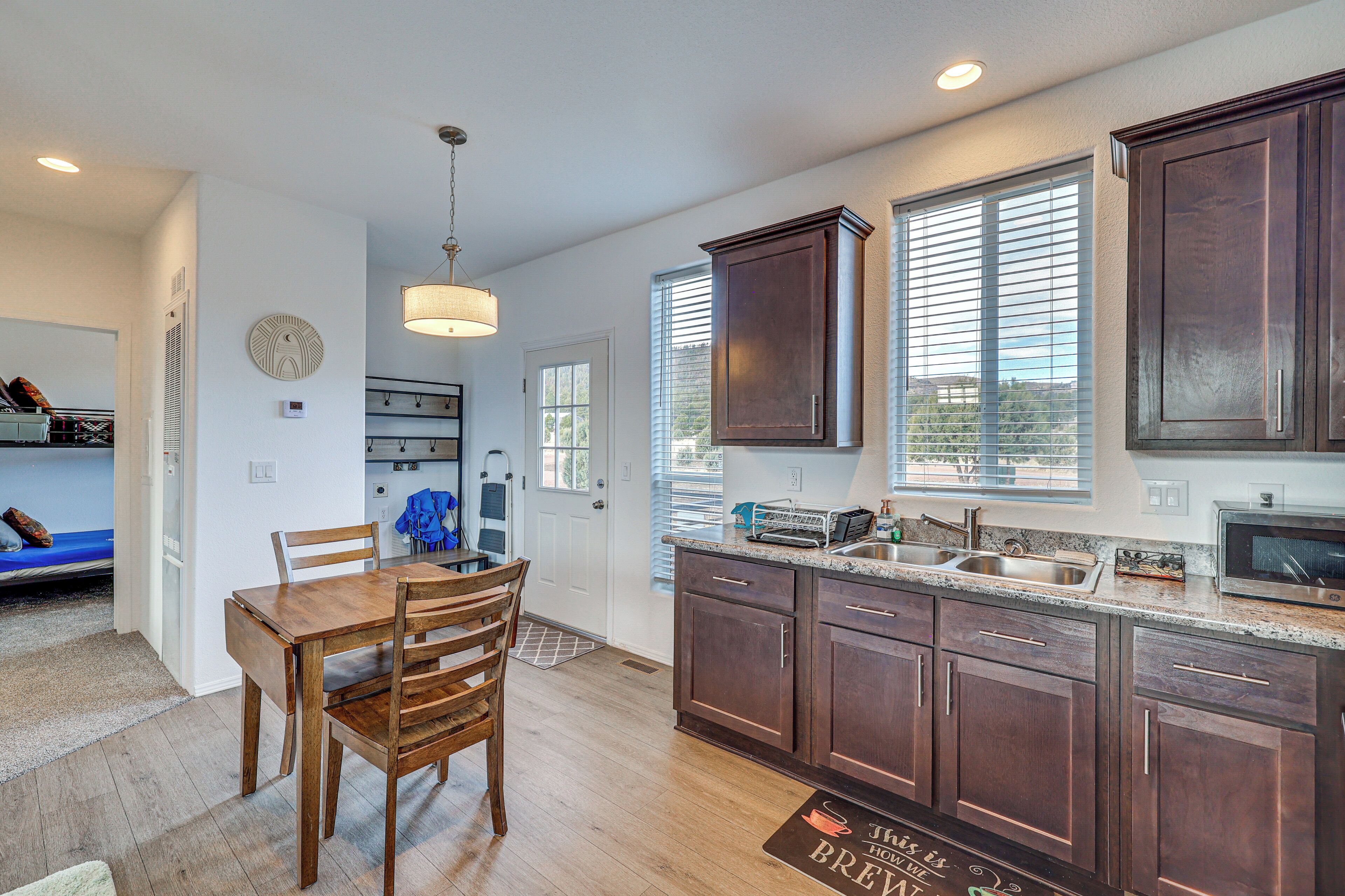 A modern kitchen with wooden cabinets, a built-in oven, and a large window.