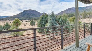 A balcony with a view of a mountainous landscape, featuring a wooden deck and metal railing. - Mountain Views & Ponderosa Pines! Arizona Escape (Eagar)