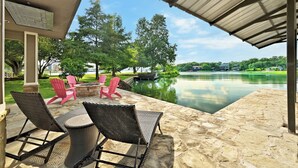 Eine Terrasse im Freien mit Steinböden, Korbstühlen und einem Tisch.