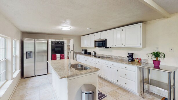 A modern kitchen with white cabinets, stainless steel appliances, and a granite countertop. - 4BR w/ Pool Table & WFH Desk, Near Fishing Pond (Quinlan)