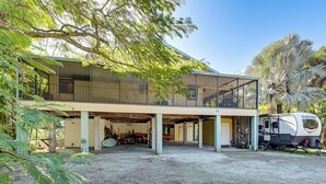 A modern house with a covered garage, a motorcycle, and a recreational vehicle parked outside.