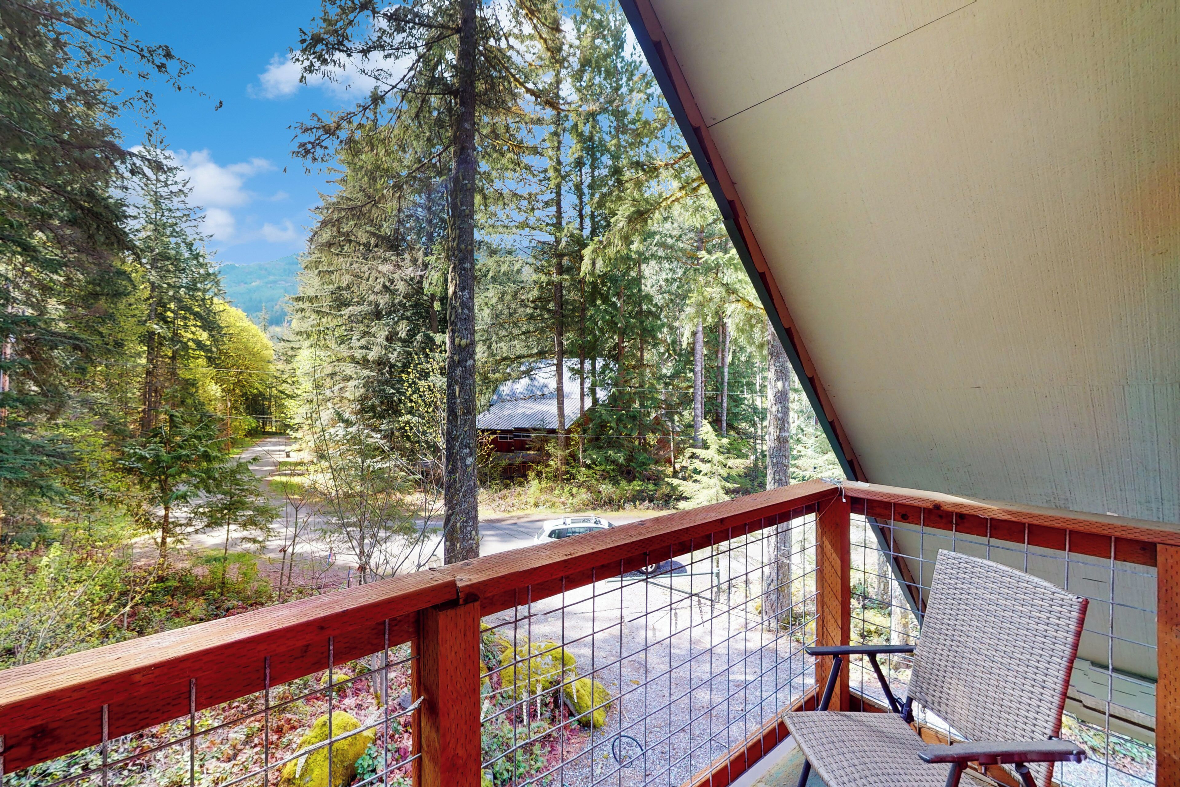 A balcony with a view of a forest and a road.
