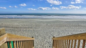 A beach with a wooden walkway leading to the water. - Myrtle Beach Resort Condo Near Golf & Ocean! (Myrtle Beach)