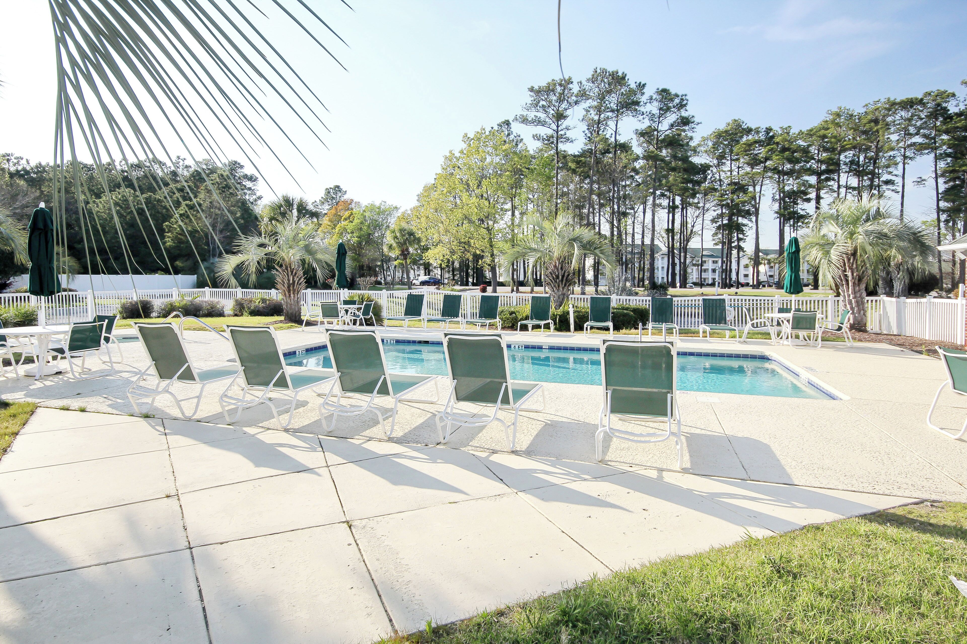 A poolside area with lounge chairs and a swimming pool.