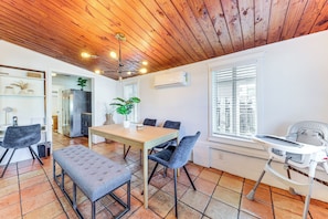 A modern kitchen with a wooden ceiling, a dining area with a table and chairs, and a baby high chair. - 5 Mi to Las Olas Beach! Bright Home w/ Fenced Yard (Fort Lauderdale)