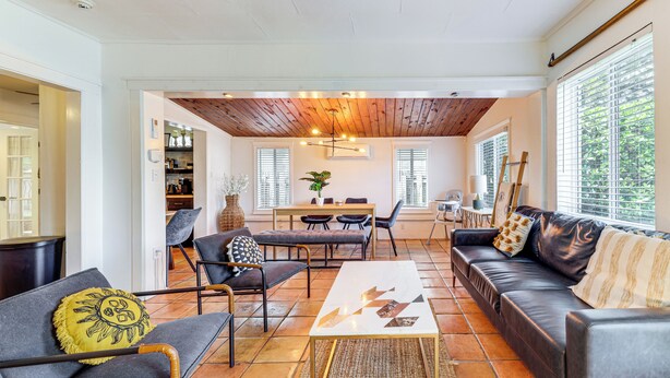 A modern living room with a sofa, chairs, a coffee table, and a dining area with a table and chairs. - 5 Mi to Las Olas Beach! Bright Home w/ Fenced Yard (Fort Lauderdale)