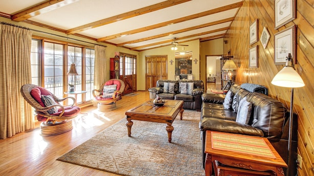 A spacious living room with wooden beams, a leather sofa, a rocking chair, and a coffee table. - 3 Mi to Ruby Falls: 'the Downer House' w/ Yard (Chattanooga)
